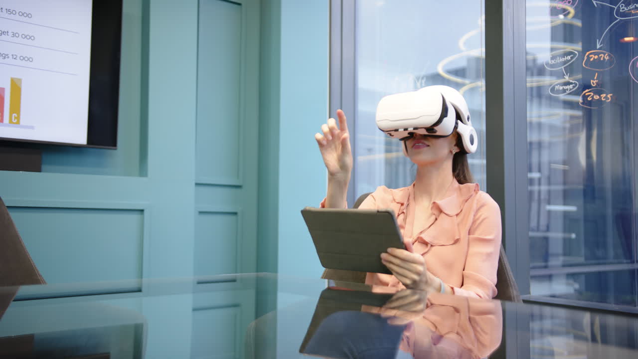 Utilizzando un visore VR e un tablet, donna che lavora in un ambiente d'ufficio moderno.