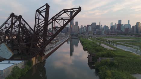 one of chicago's historical movable bridges passing in front of the chicago skyline leading to the the chicago river