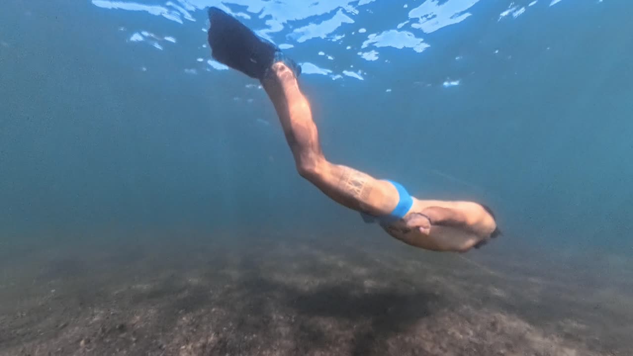 Man Free Diving Underwater with Fins