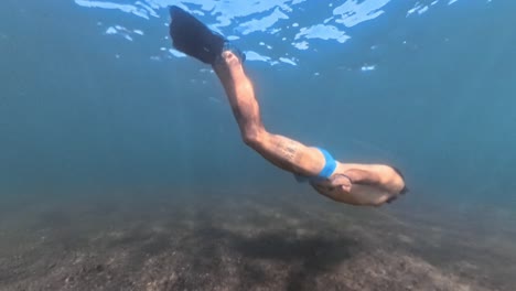 man free diving underwater with fins