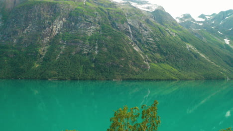 rocky mountain range and turquoise blue lakeshore of stryn in vestland county, norway