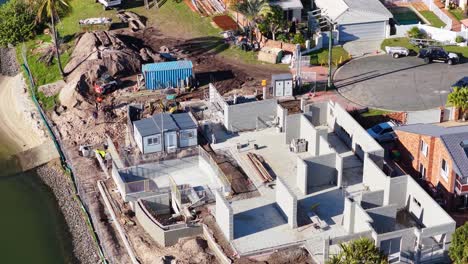 drone footage captures construction progress on luxury homes by a canal in gold coast, australia, under bright daylight