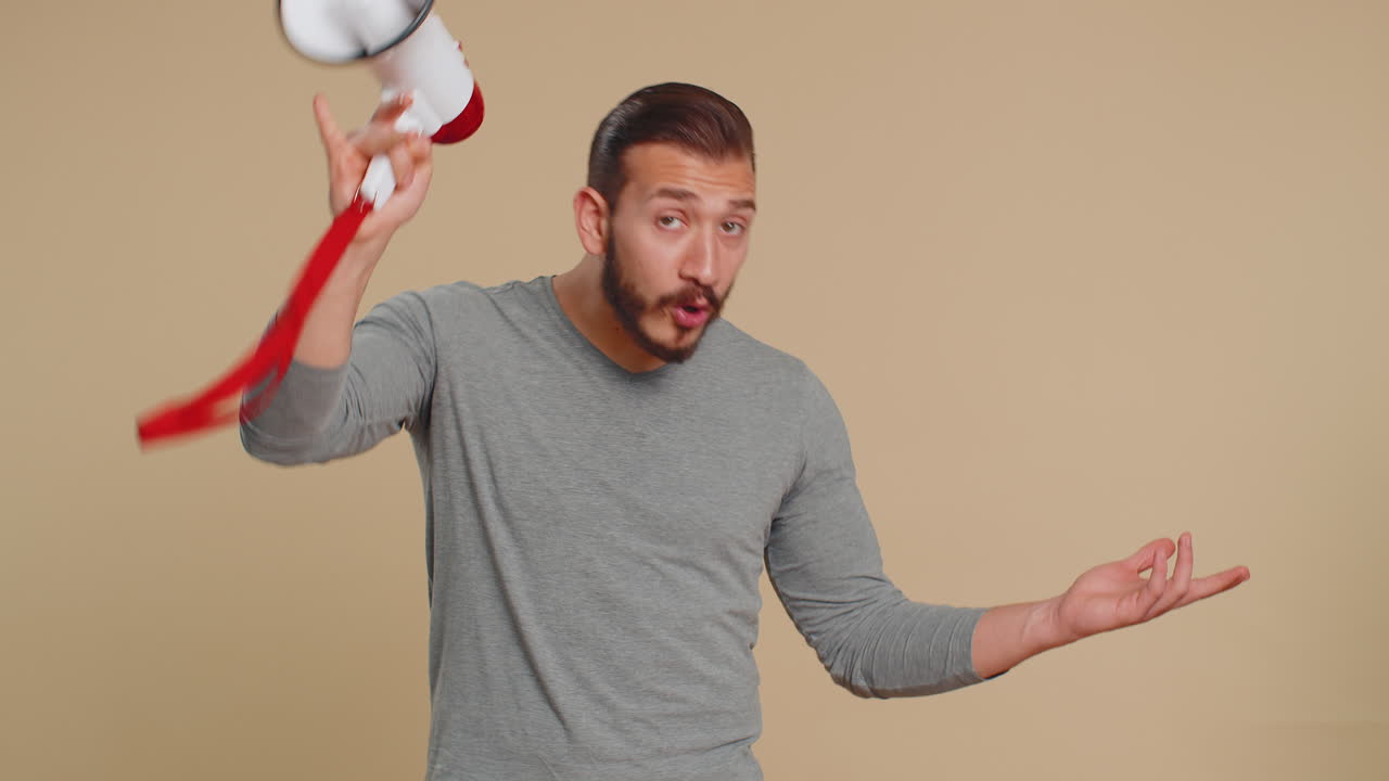 Young man scream shout in megaphone loudspeaker announces discounts sale announcing advertisement