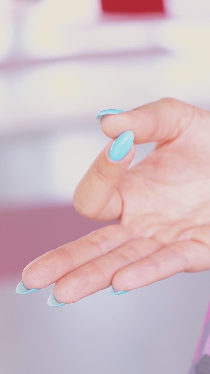 lady with manicure holds fingers in meditating mudra position sitting in special fly yoga hammock extreme close view