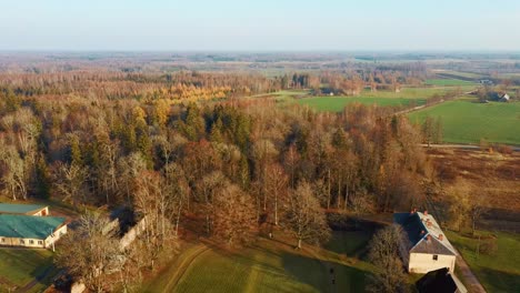 Old-Red-Brick-House,-Katvari-Manor-in-Latvia-and-Katvaru-Lake-in-the-Background