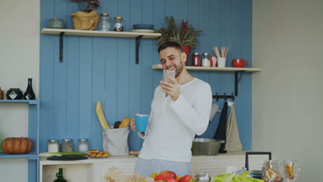 man using mobile phone in kitchen