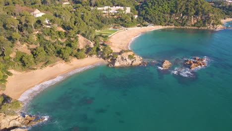 Imagen-Aérea-Con-Drone-De-Playa-Virgen-De-Lloret-De-Mar-Con-Vegetación-Verde-En-El-Mar-Mediterráneo-En-El-Mediterráneo-Santa-Cristina-Lloret-De-Mar-España-Europa