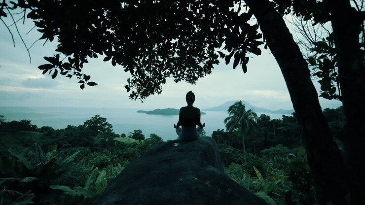 Woman Meditating on a Rock with Ocean View