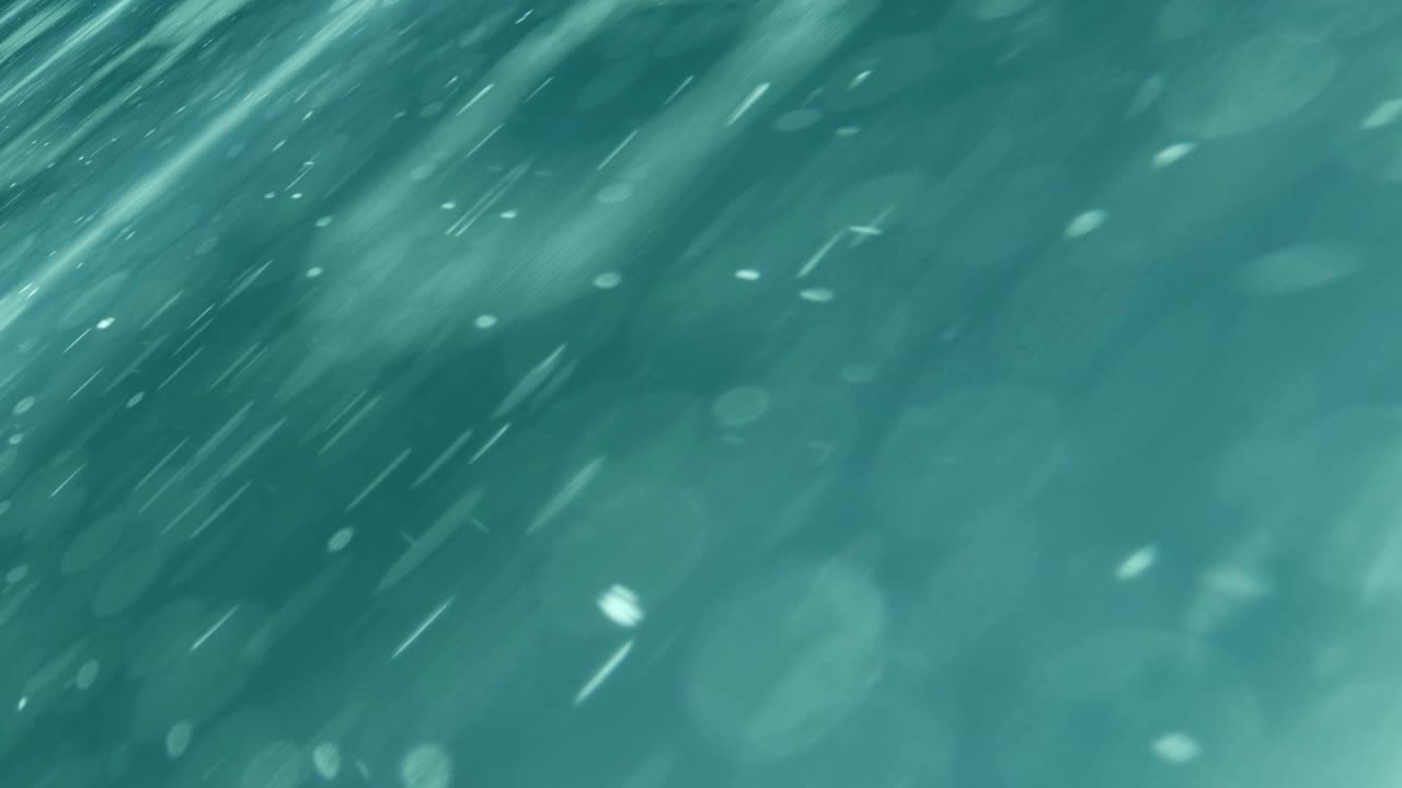 Abstract turquoise green animation of lights floating on a surface