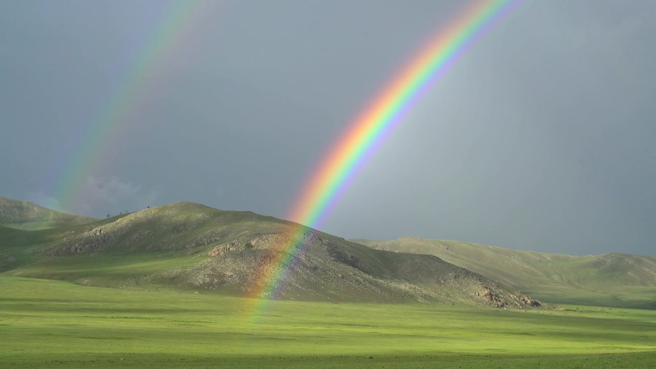 Pelangi Ganda Cerah di Atas Bukit Hijau Bergulir