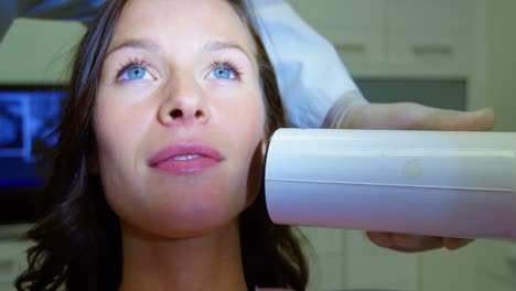 dentist examining a female patient with dental tool