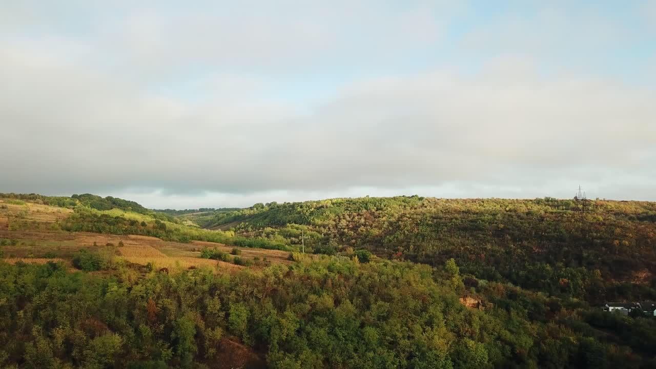 Beautiful landscape of rural place with brown meadows and fields. Panorama of natural environment with hills and forests under the sky. Slow motion of camera