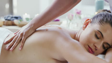 una mujer recibiendo un masaje de espalda en un spa.