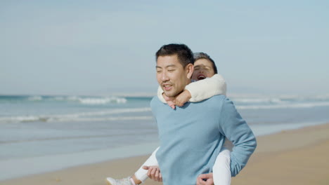 Japanischer-Vater,-Der-Mit-Seiner-Tochter-Auf-Dem-Rücken-Am-Meer-Entlang-Geht-Und-Ihr-Geschichten-Erzählt