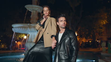 una pareja de moda posando juntos en la ciudad nocturna.