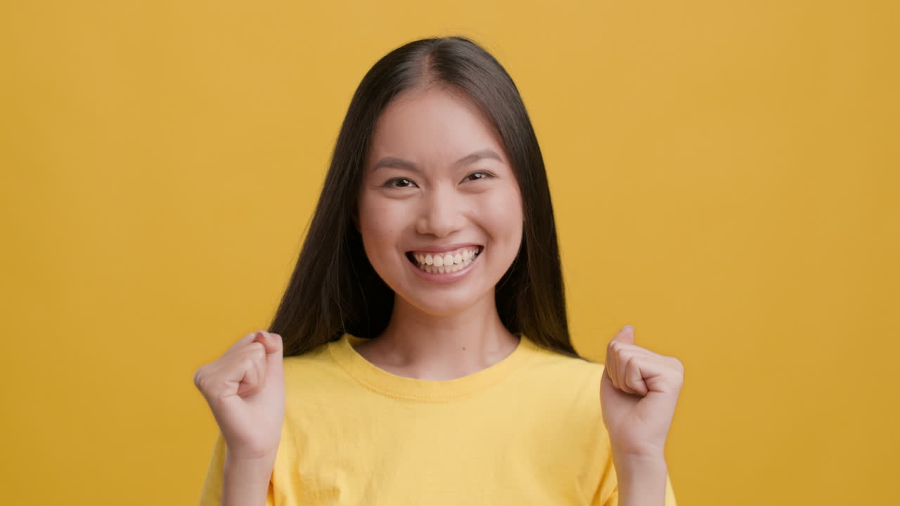 성공을 축하하는 행복한 젊은 아시아 여성