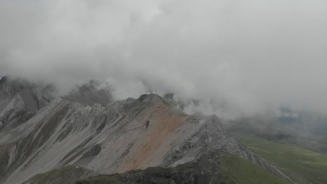 drone captures the ridge of the monzoni range during a cloudy day, following the via ferrata federspiel