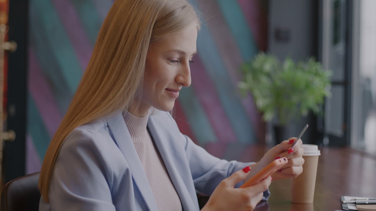 Donna che usa lo smartphone e la carta di credito in un bar