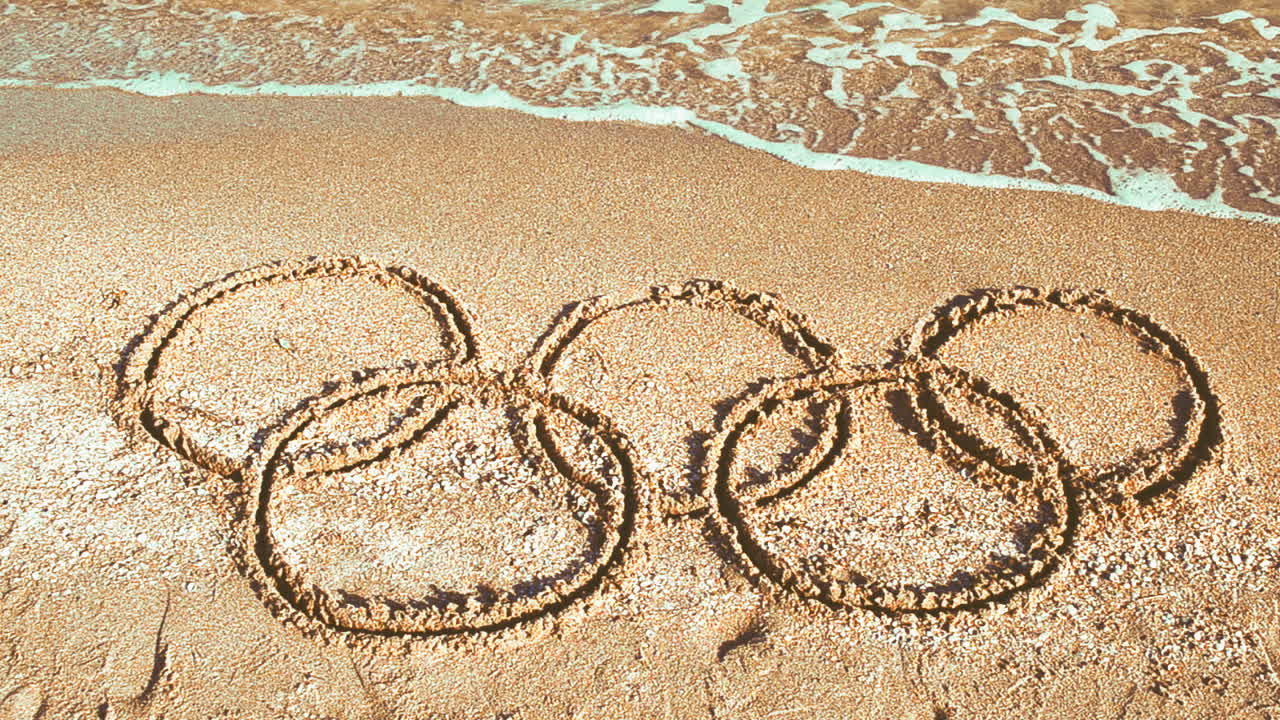 Symbol Olympic game on sand, the beach. Inscription on sand