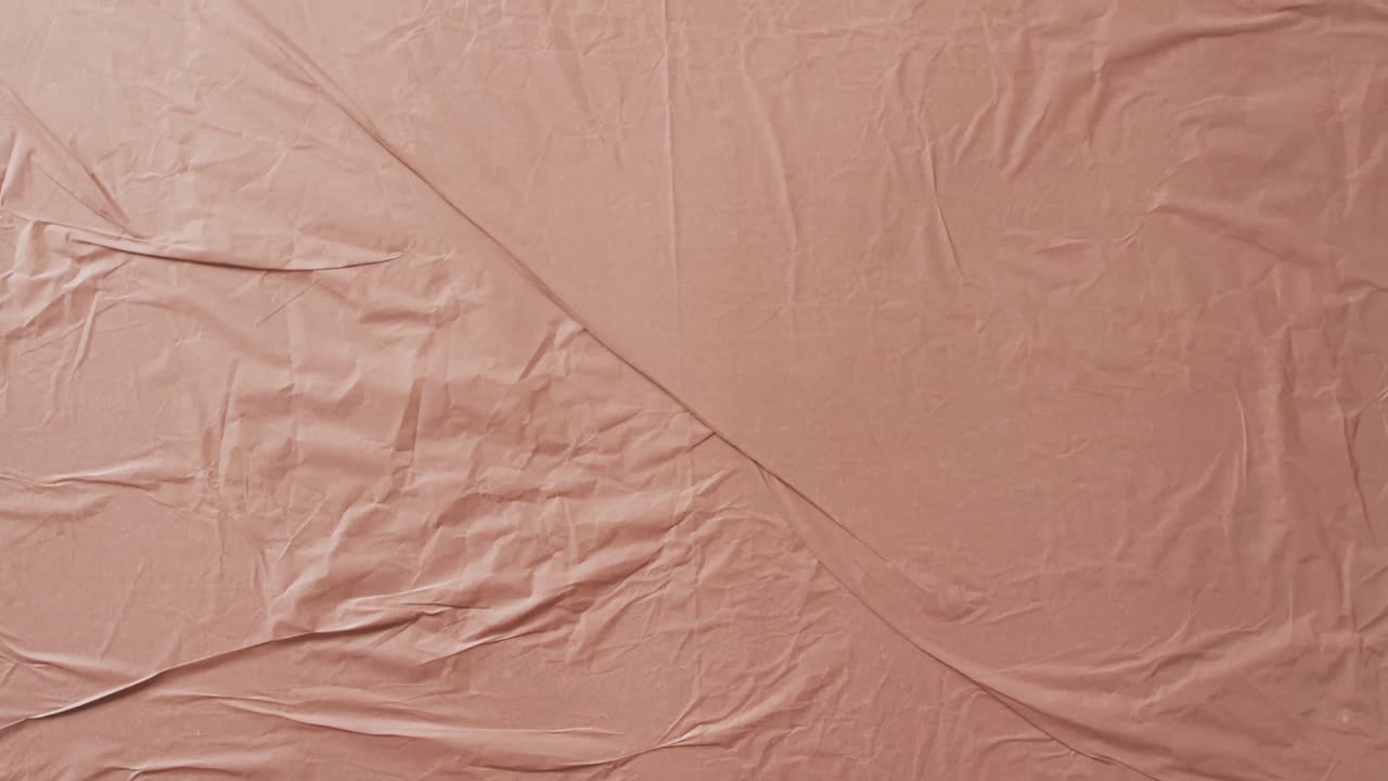 Video in primo piano di tessuto beige stropicciato con spazio per il testo