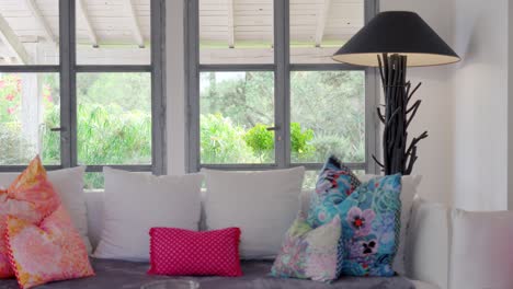 slow dolly shot of cushions placed on a sofa beside a window