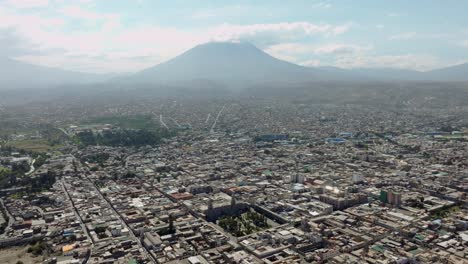 enjoy a stunning aerial shot from arequipa's plaza de armas, revealing the majestic misty volcano and the entire city in a spectacular panorama