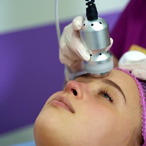 apparatus cosmetology. non-injection therapy. cosmetologist in white gloves provides procedures on the face of a beautiful girl. beauty salon