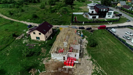 drone shot circling a unfinished house roof construction area, in a neighborhood