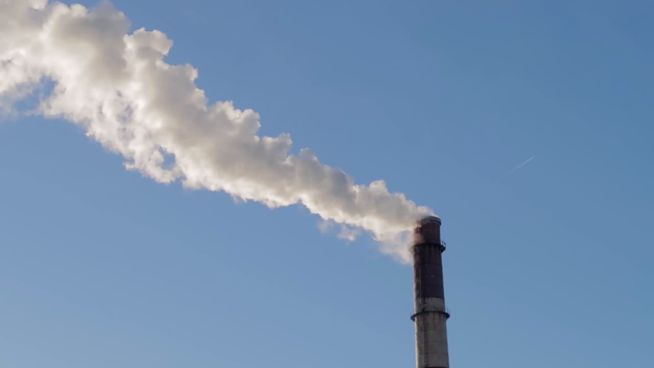 맑고 푸른 하늘에 흰 연기를 내뿜는 높은 산업용 파이프