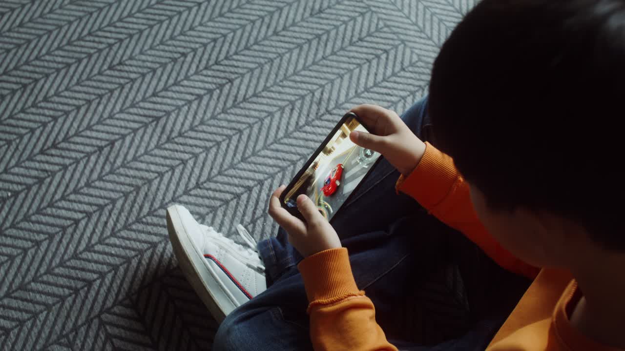 Boy playing a mobile game on a smartphone