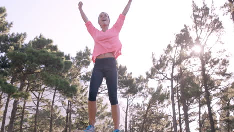 Sportswoman-raising-her-hands-after-climbing-rock