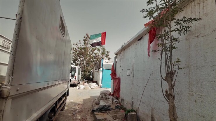 Una bandiera degli Emirati Arabi Uniti che sventola nell'aria in una città vecchia a Sharjah, Emirati Arabi Uniti.