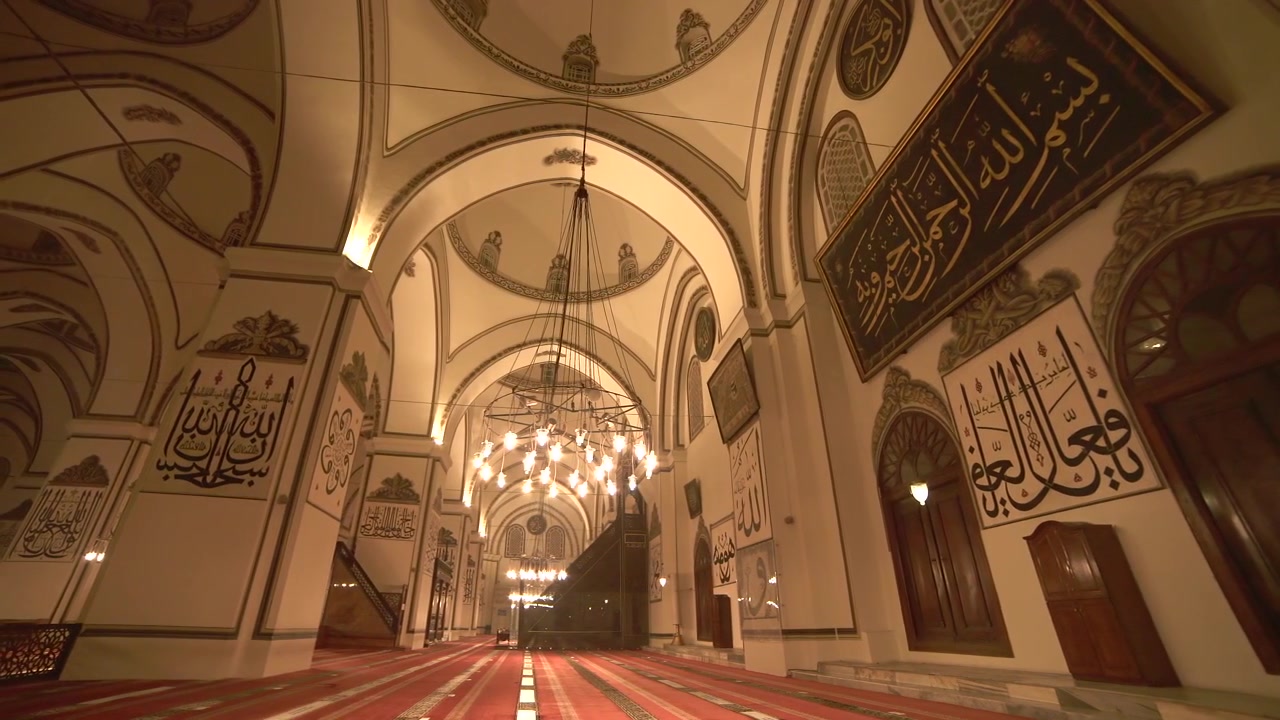 Interno di una moschea storica con calligrafia ornata e lampadari