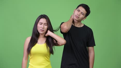 young asian couple having neck pain together