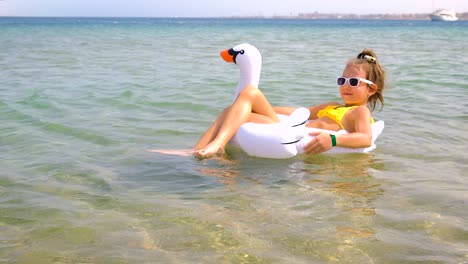 el niño nada en círculo en el mar. enfoque selectivo.