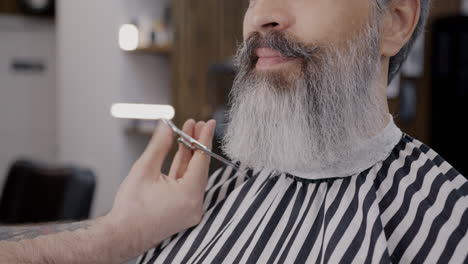 man getting a beard trim at the barber shop