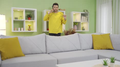 Funny-clumsy-young-man-having-misfortune-trying-to-jump-on-sofa-at-home.