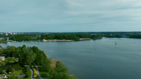 a wide shot of ukiel lake, showing the urban area of olsztyn in the background