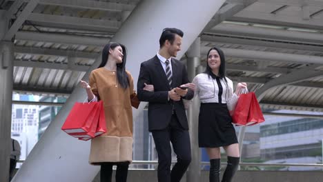 handsome man take woman shopping together in city. lady holding shopping bag on hands.