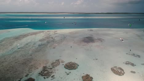 Drone-shot-turn-around-people-kitesurf-in-nature-landscape,-sebastopol-Los-Roques-Venezuela