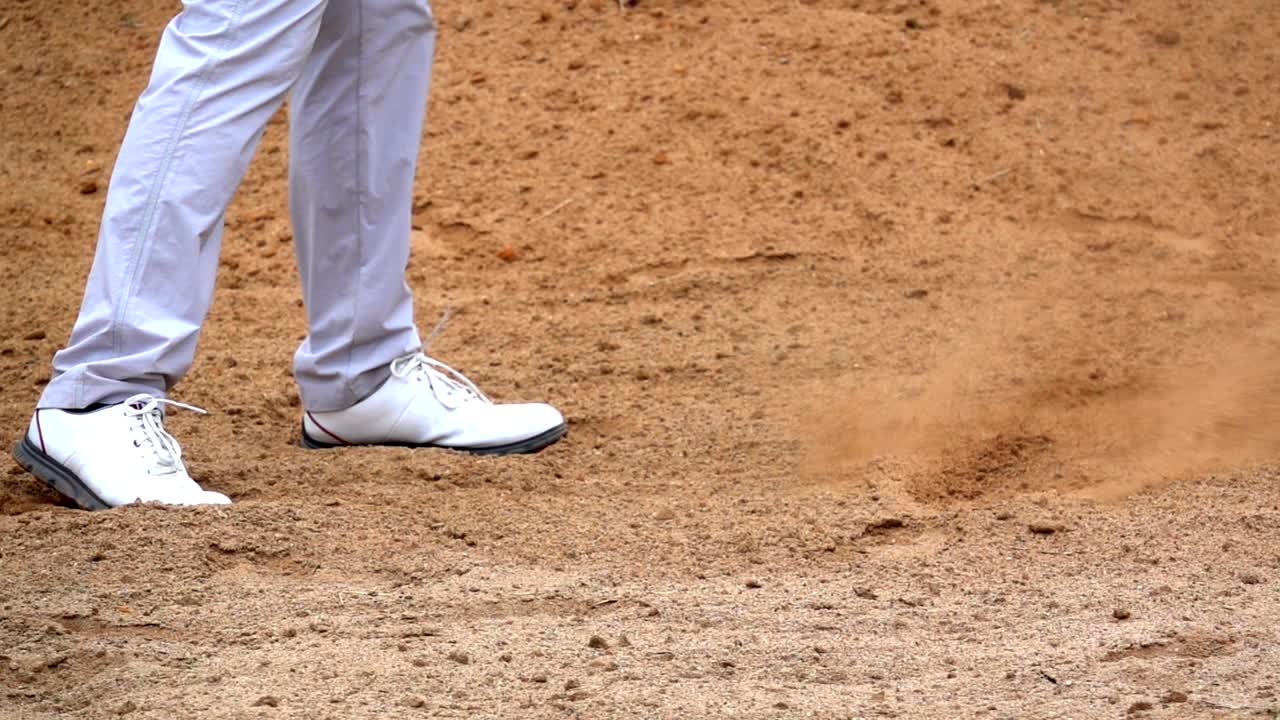 슬로우 모션 골프 개념: 골프 코스에서 골프 공을 치는 골퍼, 플레이어 스, 모래 커에서 느리게 타격하는 공.