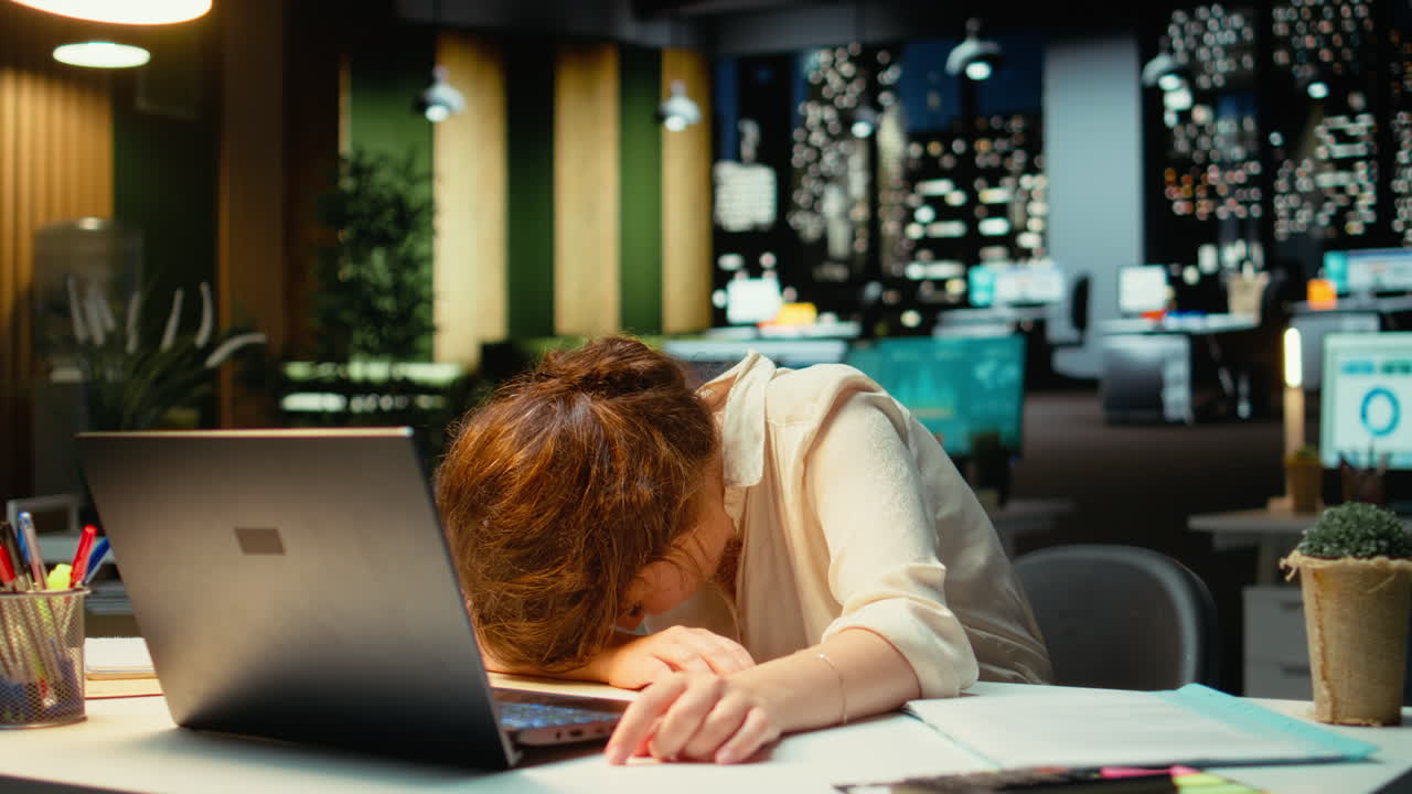 Vertical Video General manager in a dark office at midnight struggles to stay awake