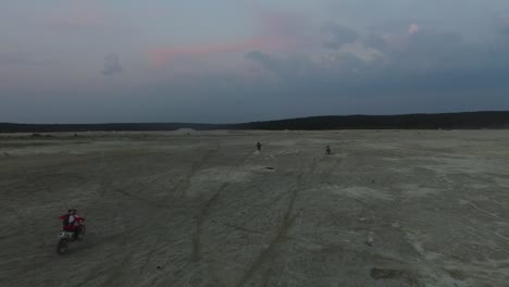 motorcyclists in sand dunes at dusk