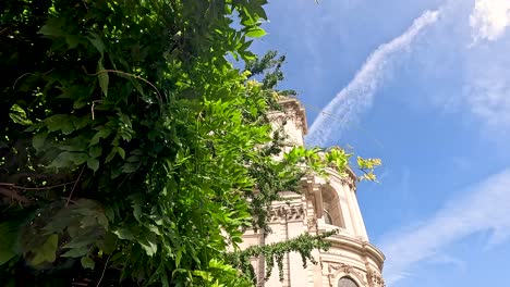 view of cathedral tower behind lush green leaves