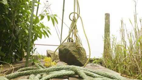 A-stone-hanging-from-a-Chinese-net-,-A-Chinese--net-stone-used-for-fishing-in-backwaters