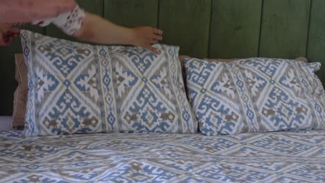 close-up of a made bed with blue and white pillows