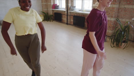 afro woman dancing with female teacher in studio