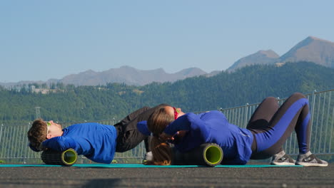 couple foam rolling outdoors