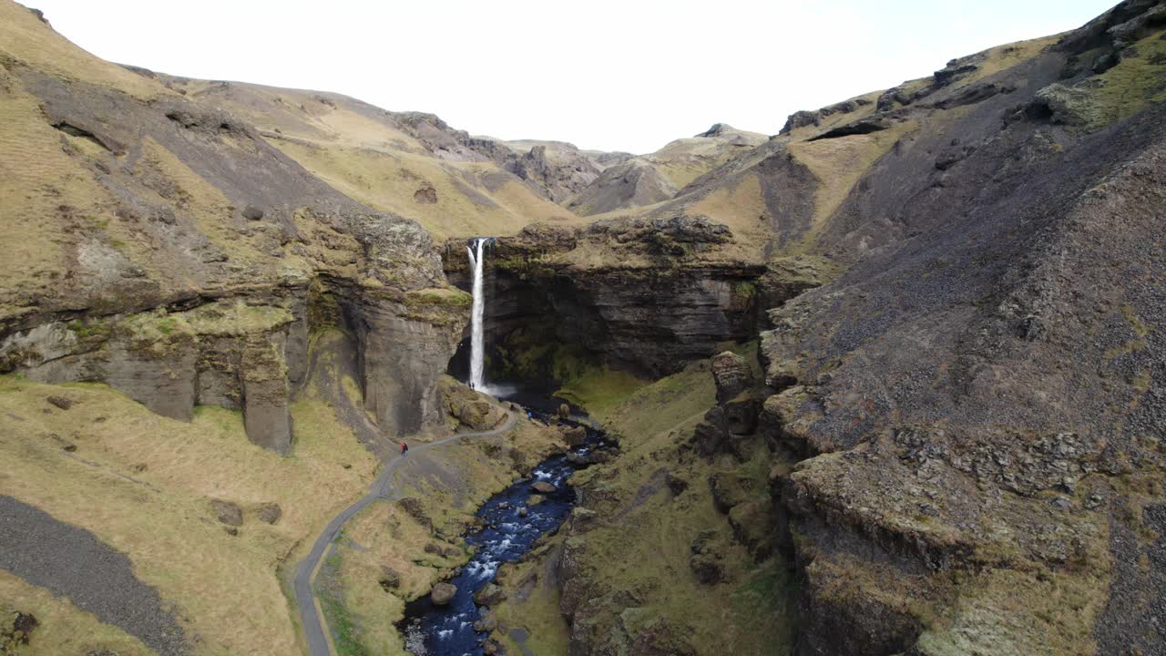 valle del río volcánico cinematográfico con cascada kvernufoss, islandia, muñeco aéreo