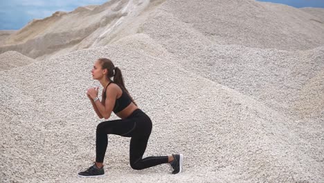woman doing lunges in a gravel pit
